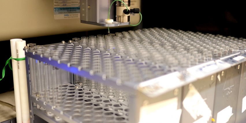 rack of test tubes under a liquid dispenser