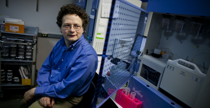 man leaning next to lab equipment
