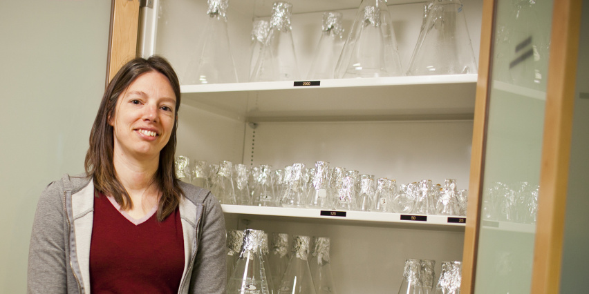 a person stands next to a cabinet of flasks